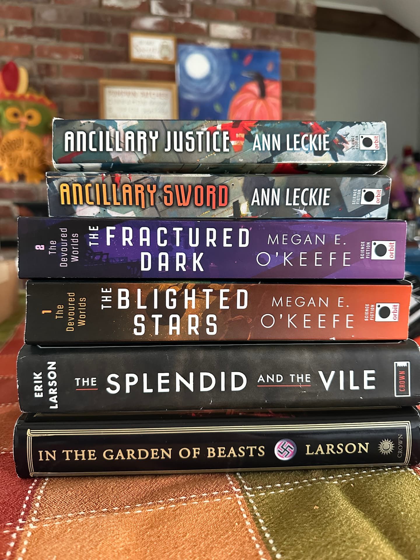 A stack of books. Ancillary Justice & Ancillary Sword by Ann Leckie. The Blighted Stars & The Fractured Dark by Megan E. O’Keefe. The Splendid and the Vile & In the Garden of Beasts by Erik Larson