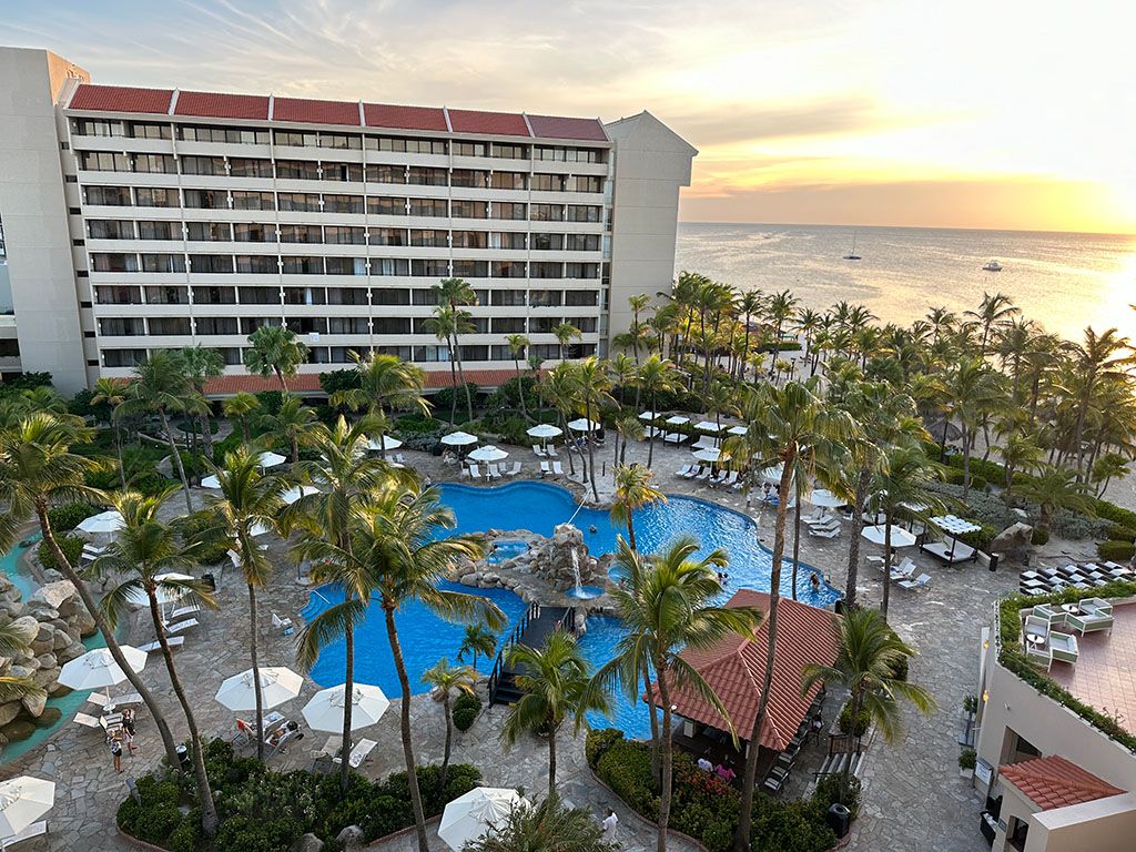 A picture of the resort we stayed at featuring a pool in the center, an apartment tower behind it, and the Atlantic Ocean to the side